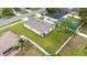 Rear aerial view of the home showcasing the fenced yard, manicured lawn, and covered patio at 10452 Elgin Blvd, Spring Hill, FL 34608