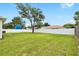 Spacious backyard with a lush lawn, white fence, and mature trees offering privacy at 10452 Elgin Blvd, Spring Hill, FL 34608