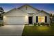 Charming single-story home featuring a two-car garage and manicured front lawn at dusk at 10452 Elgin Blvd, Spring Hill, FL 34608