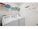 Functional laundry room with washer, dryer, and organized shelving for supplies at 10452 Elgin Blvd, Spring Hill, FL 34608