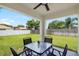 Covered patio featuring an outdoor dining table overlooking a grassy backyard at 10452 Elgin Blvd, Spring Hill, FL 34608