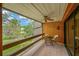 Relaxing covered balcony with brick floor, fan, table and seating overlooks a lush landscaped yard at 1111 N Bayshore Blvd # E10, Clearwater, FL 33759