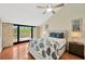 Sunny bedroom with sliding glass door to balcony, fan and ensuite bathroom at 1111 N Bayshore Blvd # E10, Clearwater, FL 33759