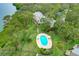 Community pool surrounded by mature trees, lush landscaping, and community homes at 1111 N Bayshore Blvd # E10, Clearwater, FL 33759