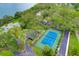 Community tennis court surrounded by mature trees and lush landscaping at 1111 N Bayshore Blvd # E10, Clearwater, FL 33759