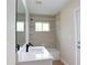 Well-lit bathroom with a modern vanity, tiled shower-tub, and neutral color scheme at 11483 Poorwill Ave, Brooksville, FL 34614