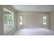 Spacious bedroom with large windows, neutral walls, and plush carpet at 11483 Poorwill Ave, Brooksville, FL 34614