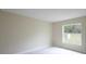 Bright bedroom with plush carpet, a large window providing ample natural light, and neutral walls at 11483 Poorwill Ave, Brooksville, FL 34614