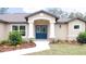 Inviting front entrance with double blue doors and decorative stone accents at 11483 Poorwill Ave, Brooksville, FL 34614