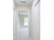 Bright hallway featuring white doors and neutral walls, leading to a sunlit room at 11483 Poorwill Ave, Brooksville, FL 34614