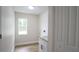 Clean laundry room with wooden floors, a utility sink, a window and ample storage space at 11483 Poorwill Ave, Brooksville, FL 34614