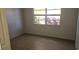 A bright bedroom with a window offering a view of outdoor greenery, and tiled floors at 11511 113Th St # 4F, Seminole, FL 33778