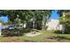 Exterior of building with inviting bench seating area under mature shade trees at 11511 113Th St # 4F, Seminole, FL 33778