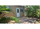 Outdoor patio with mature tropical landscaping, door to the home, and nearby windows provides a tranquil retreat at 11511 113Th St # 4F, Seminole, FL 33778