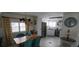 Charming dining area flowing into a bright kitchen with stainless fridge, and white wood floors at 123 S Dolphin Dr, Oldsmar, FL 34677