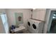 The laundry room includes a washer, dryer, storage cabinet, desk, and window at 123 S Dolphin Dr, Oldsmar, FL 34677