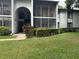 Condo exterior with screened patio, second story access and manicured landscaping at 1258 Pine Ridge W Cir # F1, Tarpon Springs, FL 34688