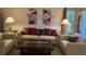 Cozy living room featuring floral art, modern furniture and a window with curtains at 1258 Pine Ridge W Cir # F1, Tarpon Springs, FL 34688