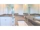 Bathroom featuring double granite vanity with white cabinets and brushed gold fixtures at 13098 Convent Garden Rd, Brooksville, FL 34614