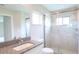 Bathroom with glass shower, tile surround, granite vanity, and brushed gold fixtures at 13098 Convent Garden Rd, Brooksville, FL 34614