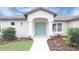 Charming home featuring a blue double door entry, new landscaping, and well manicured lawn at 13098 Convent Garden Rd, Brooksville, FL 34614