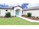 Charming home with well-manicured lawn, flower beds, and a welcoming blue front door at 13098 Convent Garden Rd, Brooksville, FL 34614