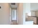 Hallway leading to a bright kitchen with granite countertops and stainless steel appliances at 13098 Convent Garden Rd, Brooksville, FL 34614