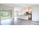 Open-concept kitchen featuring stainless steel appliances, granite countertops, and wood-look tile flooring at 13098 Convent Garden Rd, Brooksville, FL 34614