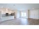 Bright, open-concept living area with wood-look tile flooring and plenty of natural light at 13098 Convent Garden Rd, Brooksville, FL 34614