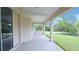 Covered porch perfect for outdoor living, with a view of the yard and adjacent trees at 13098 Convent Garden Rd, Brooksville, FL 34614