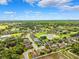 Expansive aerial view showcasing a tranquil residential community with lush greenery, sparkling ponds, and clear blue skies at 13523 Meadow Golf Ave, Hudson, FL 34669