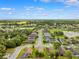 Breathtaking aerial view of a residential area featuring verdant landscaping, scenic ponds, and a clear, blue sky at 13523 Meadow Golf Ave, Hudson, FL 34669