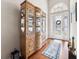 Elegant foyer featuring hardwood floors, display cabinet, and a decorative glass front door at 13523 Meadow Golf Ave, Hudson, FL 34669