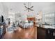 Open-concept living space with hardwood floors, fan, and a view of kitchen and front entry at 13523 Meadow Golf Ave, Hudson, FL 34669