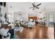 Open-concept living space with hardwood floors, fan, and view of the kitchen and front entry at 13523 Meadow Golf Ave, Hudson, FL 34669