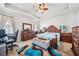 Spacious main bedroom with tray ceiling, wood furniture, a ceiling fan, and cozy carpet at 13523 Meadow Golf Ave, Hudson, FL 34669
