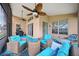 Relaxing screened-in patio with stylish wicker furniture, ceiling fans, and views of the surrounding landscape at 13523 Meadow Golf Ave, Hudson, FL 34669