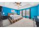 Bright bedroom with blue walls, carpeted floor, a ceiling fan, and a pallet bed frame at 13722 Lakemont Dr, Hudson, FL 34669