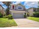 Charming home featuring a two-car garage, fresh landscaping, and a cozy front entrance at 13722 Lakemont Dr, Hudson, FL 34669