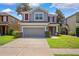 Two-story home featuring a two-car garage, well-maintained lawn, and lovely curb appeal at 13722 Lakemont Dr, Hudson, FL 34669