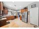 Large kitchen with ample counter space, stainless steel refrigerator, and a view into the living area at 13722 Lakemont Dr, Hudson, FL 34669