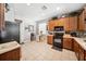 Bright kitchen with wood cabinets, black appliances, and a small dining table for casual meals at 13722 Lakemont Dr, Hudson, FL 34669