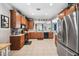 Spacious kitchen featuring wood cabinets, tile floors, and stainless steel appliances, connecting to the dining area at 13722 Lakemont Dr, Hudson, FL 34669
