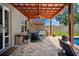 Comfortable outdoor living on the patio area featuring stone flooring, pergola, and stylish furniture at 13722 Lakemont Dr, Hudson, FL 34669