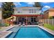 In-ground backyard swimming pool area featuring a covered patio, lounge chairs, and well-maintained landscaping at 13722 Lakemont Dr, Hudson, FL 34669
