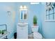 Powder room with white vanity, toilet, neutral paint, and decorative mirror at 1411 Tessano Pl, Palm Harbor, FL 34683