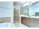 Bathroom featuring a glass-enclosed shower, tiled floors, and a spacious vanity with modern fixtures at 1411 Tessano Pl, Palm Harbor, FL 34683