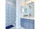 Stylish bathroom featuring a vanity, decorative mirror, and a shower with a patterned curtain, for added privacy at 1411 Tessano Pl, Palm Harbor, FL 34683