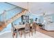 Dining room with wood table, stairs to the second floor, light fixture, and view of the living room at 1411 Tessano Pl, Palm Harbor, FL 34683