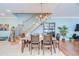 Dining room adjacent to staircase featuring a dark wooden table, chairs, and modern chandelier at 1411 Tessano Pl, Palm Harbor, FL 34683